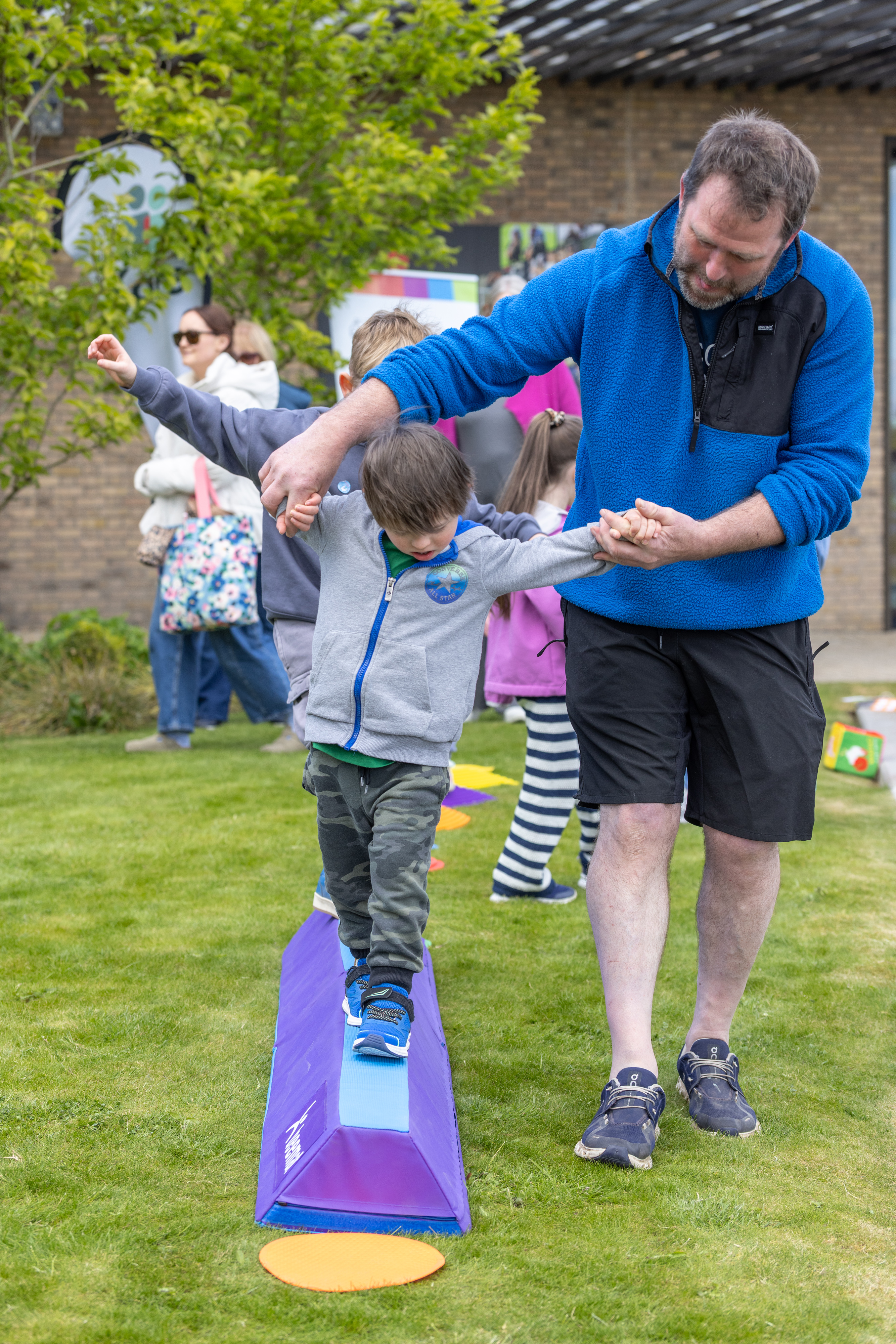 Two people playing on a balancing beam. 